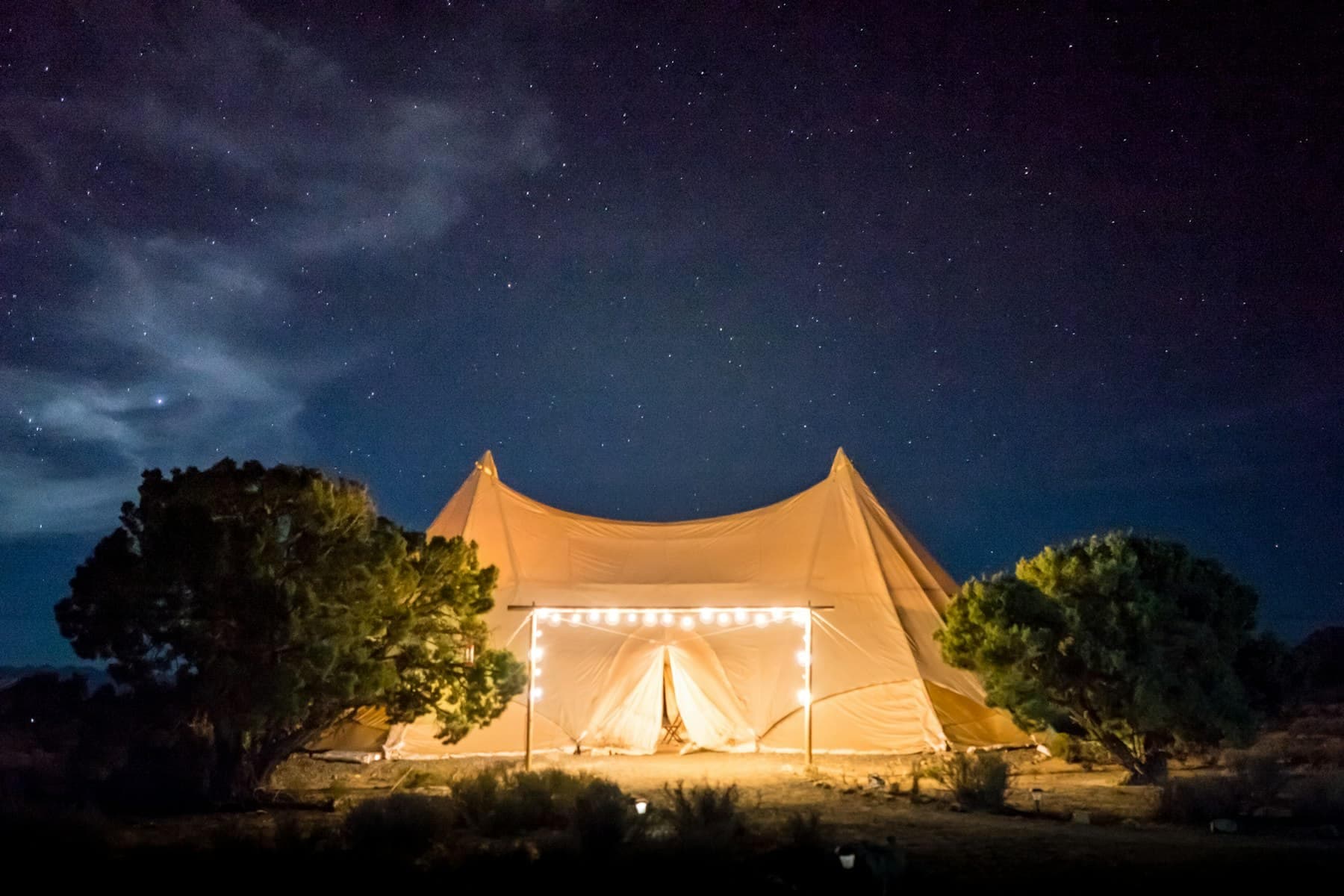 Carpa iluminada en el jardín bajo un cielo estrellado