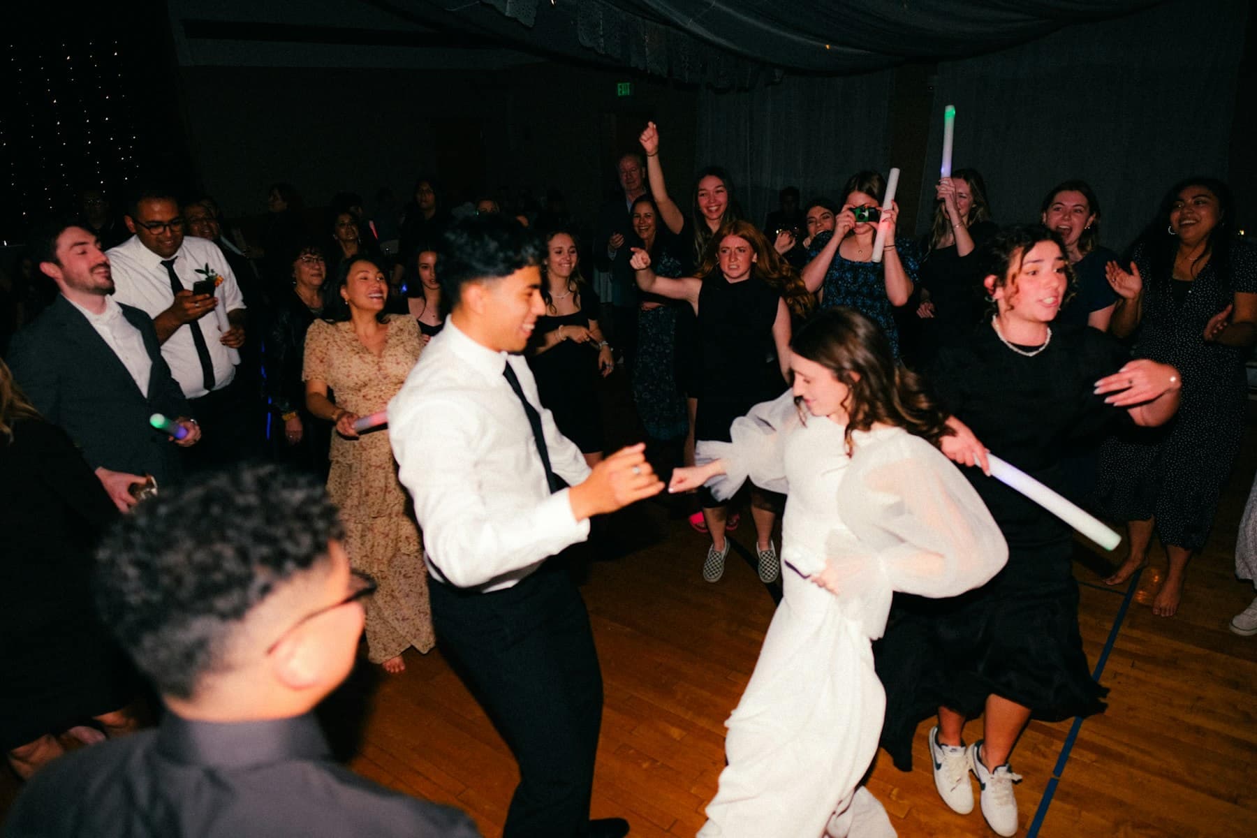 Novios bailando rodeados de invitados en la pista